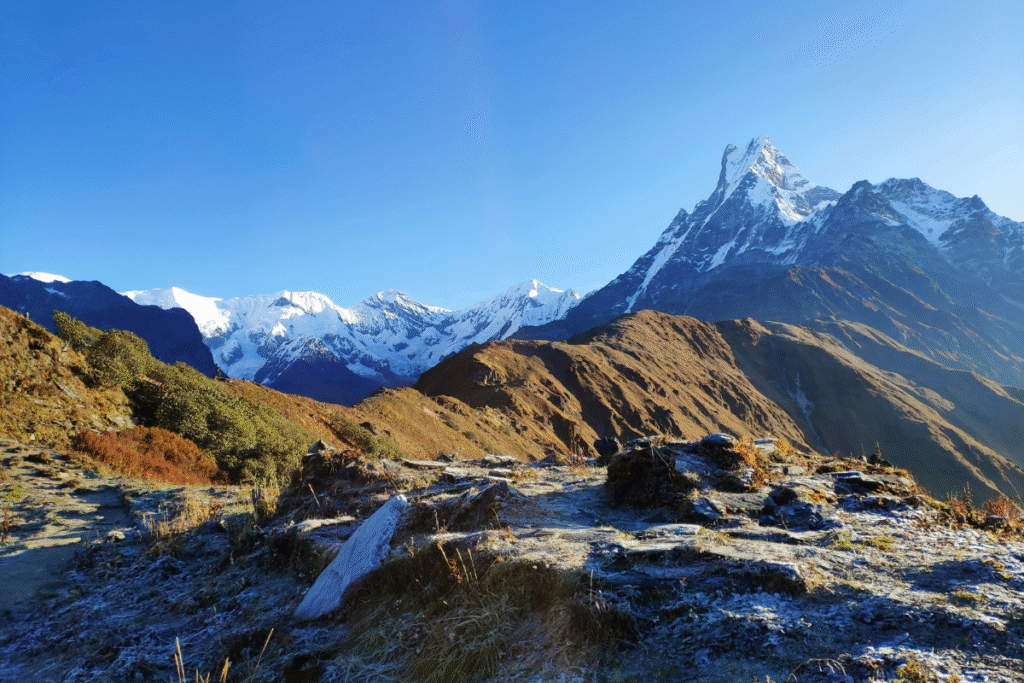 Snow-dusted trail with a clear view of Mardi Himal and Machapuchare peak in the Himalayas.