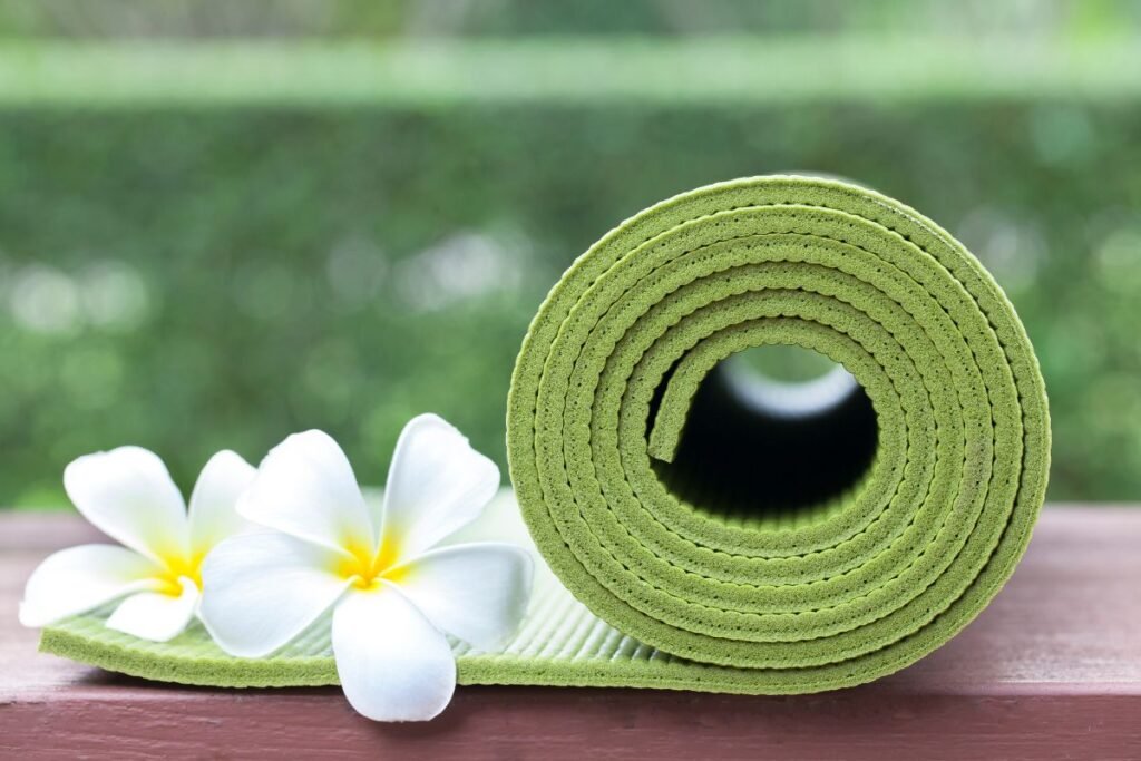 "Green yoga mat and flower"